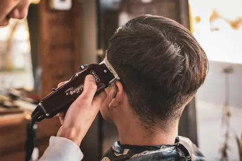 Criança sorridente a cortar o cabelo